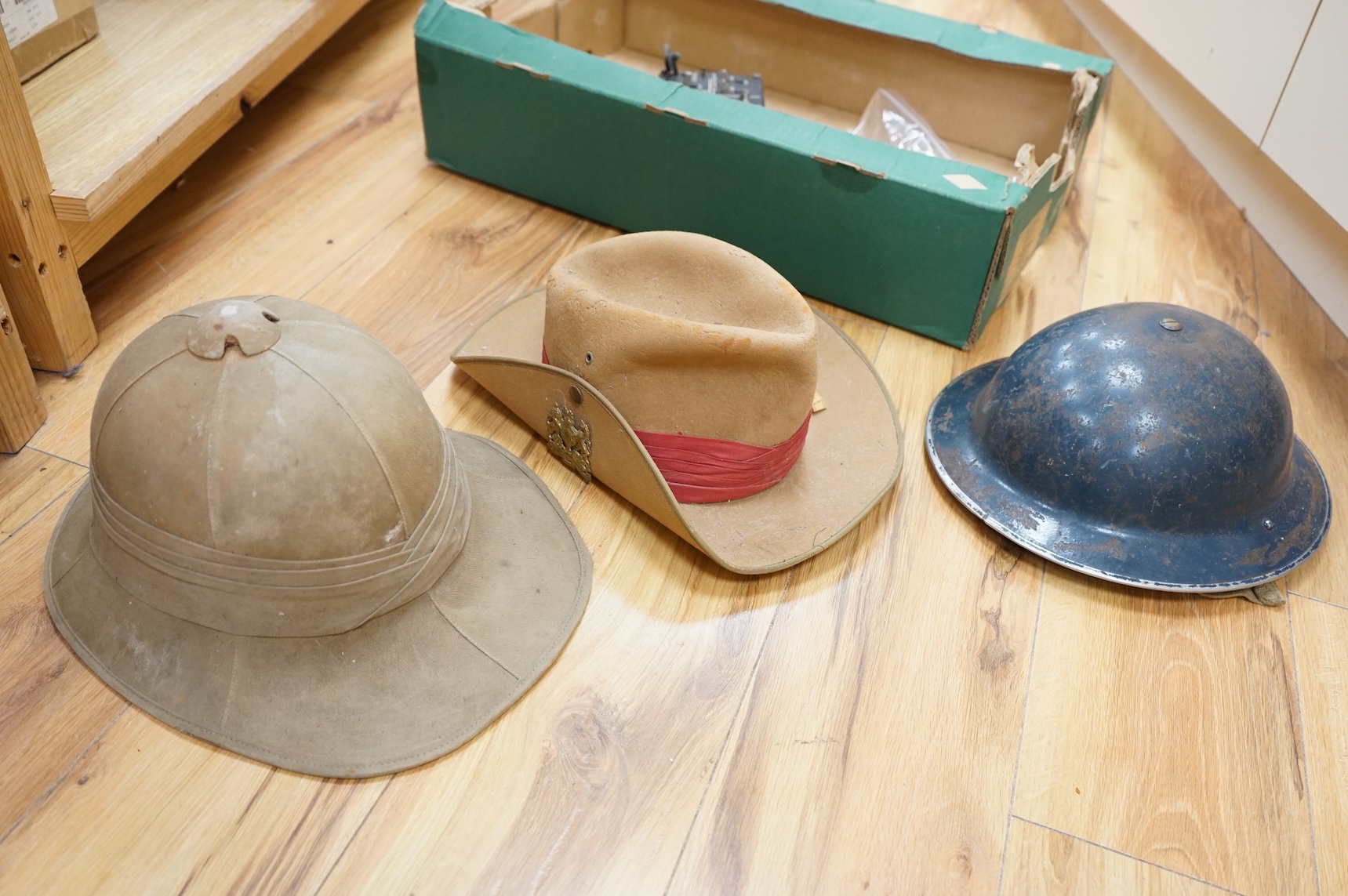 A collection of military related items, including an instrument panel from a WWII RAF Lancaster bomber aircraft, a Bosun’s whistle, a Heckler and Koch ‘bullet’ pen, a WWII tin hat (possibly police), a pith helmet, an Aus